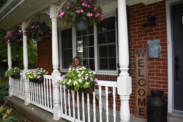 Nancy Pym's Colonel Talbot Road porch is a charmer.  The pretty impatiens pots and other garden enhancements are her handiwork as well as several wooden touches. She crafted the bench and 'welcome' sign, plus repainting an antique milk can. Pym and husband Skip have lived here 23 years, also sharing the home front with sons Jake and Tyson. (BARBARA TAYLOR, The London Free Press)