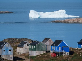 Icebergs float behind the town of Kulusuk in Greenland on August 16, 2019. - Greenland is not for sale, the mineral-rich island said on August 16, 2019, after a newspaper reported that US President Donald Trump was asking advisers whether it's possible for the United States to buy the Arctic island.