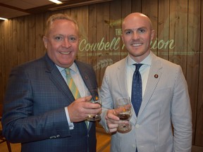 Cowbell Brewery founder Steven Sparling, left, and son Grant, chief development officer, enjoy a post-dinner Almanac served for the first time Friday during the second annual Cowbell reunion dinner. (Wayne Newton photo)