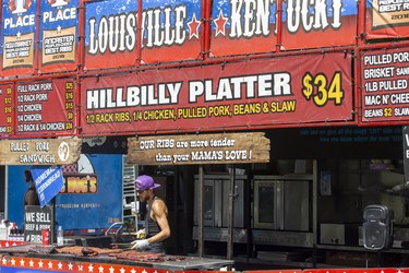 Skyler (Little Lito) Davidson of Bear Creek, Ky., grills racks of ribs at the Kentucky Smoke House stand on the first day of Rib Fest in Victoria Park in London, Thursday, Aug. 1, 2019. Derek Ruttan/The London Free Press