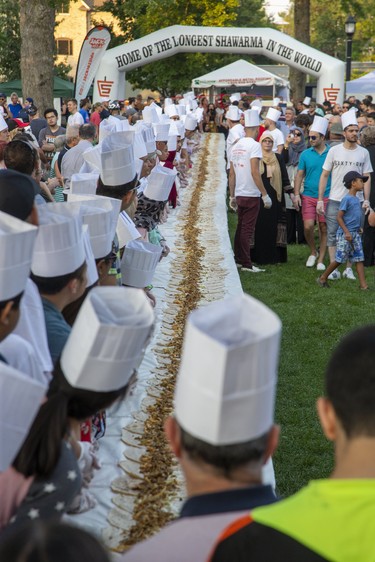 Dozens of volunteers wait for the signal to simultaneously roll a 150 foot long chicken shawarma at Rib Fest in Victoria Park in London, Ont. on Friday August 2, 2019.  If successful they will beat the world record of 138 feet. Derek Ruttan/The London Free Press/Postmedia Network
