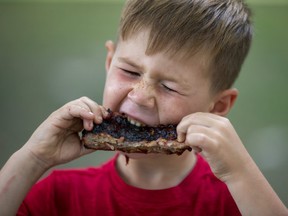 Cohen Dyke rips into lunch at the London Rib Fest and Craft Beer Festival in Victoria Park in London on  Monday Aug. 5, 2019. "I love ribs better than anything," said the five-year-old Aylmer native. "They're amazing, amazing, amazing!" He was visiting with his dad Johnny, mom Netty, brother Tucker and sister Brianna. Derek Ruttan/The London Free Press