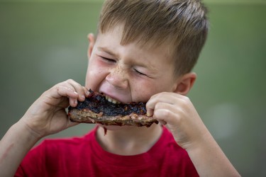 Cohen Dyke rips into lunch at The London Rib Fest and Craft Beer Festival in Victoria Park in London, Ont. on Monday August 5, 2019. "I love ribs better than anything," said the five-year-old Aylmer native. "They're amazing, amazing, amazing!" He was visiting with his dad Johnny, mom Netty, brother Tucker and sister Brianna.Derek Ruttan/The London Free Press/Postmedia Network