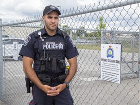 Constable Justin Fehr stands in the parking lot of the St. Thomas Police department  in St. Thomas, Ont. on Friday August 23, 2019.  The parking lot has been designated as and Internet Exchange Zone. (Derek Ruttan/The London Free Press)