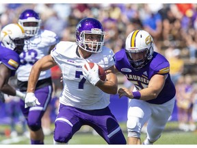 Western Mustang receiver Cole Majoros eludes Laurier Golden Hawk full back Liam Spencer-Enright during their season opener at University Stadium in Waterloo on Sunday. (Derek Ruttan/The London Free Press)