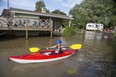 The Riker Carlsen, 9, and his brother Keller, 11, of Chatham, paddle their kayaks through the front yards of neighbours of their grandfather Randy Morton in Erieau on Tuesday Aug. 27, 2019. The boys were staying with their grandfather, whose trailer is on higher ground and was untouched by the higher water levels. (Derek Ruttan/The London Free Press)