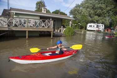 The Riker Carlsen, 9, and his brother Keller, 11, of Chatham,  paddle their kayaks through the front yards of neighbours of their grandfather Randy Morton in Erieau on Tuesday Aug. 27, 2019. The boys were staying with their grandfather, whose trailer is on higher ground and was untouched by the higher water levels. Derek Ruttan/The London Free Press