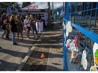 People look at painted hearts decorating a fence that surrounds homes that were damaged and destroyed by a gas explosion two weeks ago in London. A street party was held in support of the neighbourhood on Wednesday. (Derek Ruttan/The London Free Press)