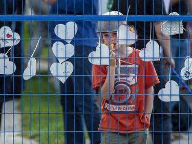 Nine-year-old Jude Eakins looks at painted hearts decorating a fence that surrounds homes that were damaged and destroyed by a gas explosion two weeks ago in London. A street party was held in support of the neighbourhood on Wednesday. (Derek Ruttan/The London Free Press)