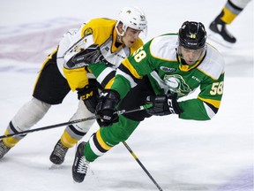 London Knights defenceman Bryce Montgomery takes flight while being tripped by Anthony Tabak of the Sarnia Sting during the first period of their game in London on Friday. (Derek Ruttan/The London Free Press)