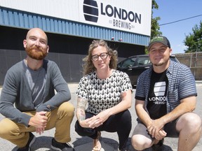 Artist Jesse Watson, Marianne Griffith of Green Economy London and Jeff Pastorius of On the Move Organics and London Brewing show off a storm sewer grate that will be the centre of a painting to illustrate the importance of not putting wastes into the storm sewer system in London, Ont.  Mike Hensen/The London Free Press