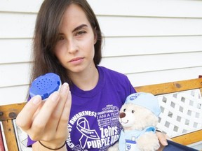 Dylan Di Girolamo, holds up a small speaker that has a pre-recorded first aid message about epilepsy as part of her epilepsy kit that she entered to win 2nd place in a competition. Di Girolamo's kit also features a timer (it's recommended to call 911 if a seizure lasts over 5 minutes), a pamphlet on epilepsy as well as a teddy bear called Nurse Nick, who also can be pressed to give instructions via a microphone embedded in the bear. Photograph taken on Monday August 12, 2019.  Mike Hensen/The London Free Press/Postmedia Network
