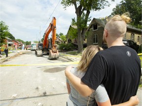 Laura Earle and her boyfriend Chris Patterson look at their home, built in 1907, at 448 Woodman Ave. The house, which is next to the blast site at 450 Woodman, has been demolished. (Mike Hensen/The London Free Press)