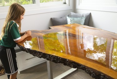 A live edge dining table contains coins from the birth year of the family members at the home of Glen and Denise Martins at their Byron home that features an artificial turf soccer pitch in London, Ont.  Mike Hensen/The London Free Press/Postmedia Network