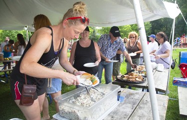 Maaike VanJecek spoons up some pasta salad during a picnic in support of Old East London village held at Boyle Memorial Community Centre on Sunday August 18, 2019. About 400 people attended the free event. (Mike Hensen/The London Free Press)