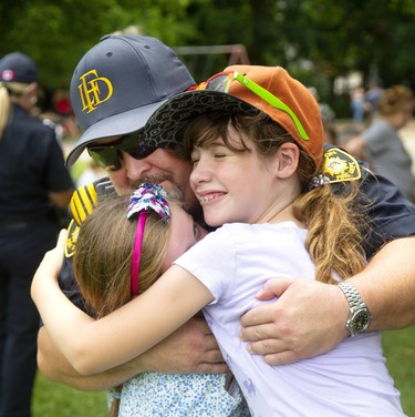 Deputy fire chief Jack Burt gets a warm hug from Gabby O'Neil, 9 and Pearl MacRae Hoy 9, at Boyle Memorial Community Centre on Sunday August 18, 2019. About 400 people attended the free event. (Mike Hensen/The London Free Press)