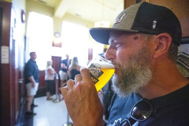 Aaron Goss of London sips a beer waiting for the Old East Village benefit concert being held at the Aeolian Hall on Dundas Street in London.  Mike Hensen/The London Free Press/Postmedia Network