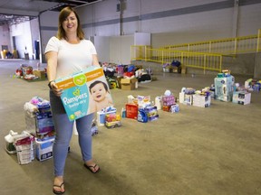 Kate Graham, a volunteer with the Old East Village Community Association holds some of the urgent necessities of life that are being sorted for the 11 families most directly affected by last weeks blast on Woodman Avenue in London. (Mike Hensen/The London Free Press)