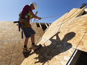 Rick Haasen of Shedden walks on a section of roof he was finishing on a Doug Tarry home being constructed in Strathroy west of London.  Homes are being built in big numbers all around London in Dorchester, Komoka, Mt. Brydges, Strathroy and Lucan. (Mike Hensen/The London Free Press)