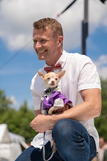 Kevin Kooger holds Waylen, a 10-year-old chihuahua, as they model in Pawlooza's dog fashion show. Waylen was adopted by Darlene Altmann from Texas Chihuahua Rescue one year ago.
