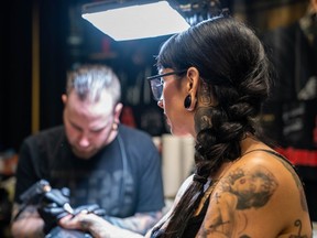 Jessie Lee, of Hollywood, California, gets a Tim Horton's cup tattoo from Will Smink, owner of London's Ink by Smink Tattoos, at the Inked Circus Tattoo Expo Sunday. (MAX MARTIN, The London Free Press)