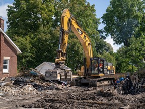 Crews continue to clean up on Woodman Avenue Saturday. Three houses have been completely demolished.