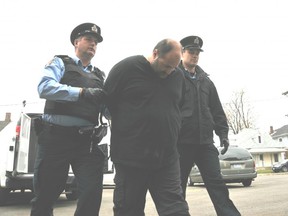In this file photo from 2012, Chatham-Kent police special constables John Carter, left, and Tyler Bergsma, right, escort Ronald Inghelbrecht of Chatham to the local jail after being sentenced to five years for sexual assault and two years for possession of child pornography. (Diana Martin/The Daily News)