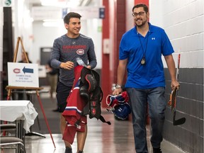 Canadiens prospect Nick Suzuki and Charles Demers of the team's marketing department walk down corridor at the Bell Sports Complex in Brossard on Day 1 of training camp on Sept. 12, 2019.