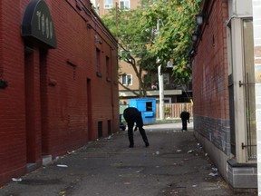 London police forensic officers scour an alley beside two bars along downtown London's Richmond Row, which leads to a parking lot where police say three people were injured in a shooting early Sunday. Photo taken Sunday Sept. 30, 2019. (Jane Sims/The London Free Press)