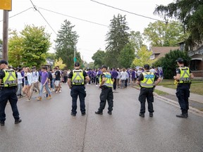 Police officers stand by as students and young people crowd onto Broughdale Avenue during the annual Fake Homecoming (FoCo) celebrations on Saturday, Sept. 28, 2019. (The London Free Press file photo)