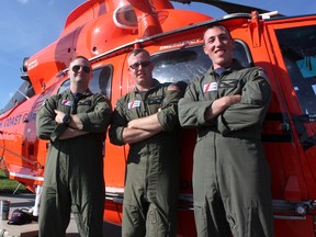 Jake Wawrzyniak, Sean Farrar and Nicholas Consenza, members of the US Coast Guard, outside a search and rescue helicopter called "The Dolphin" at Airshow London on Saturday, Sept. 14, 2019. (MEGAN STACEY/The London Free Press)