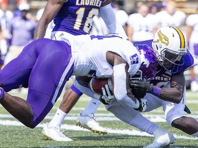 Laurier Golden Hawk defensive back Will Amoah ends the forward progress of Western Mustang running back Jonathan Femi-Cole during their season opener at University Stadium. Derek Ruttan/The London Free Press file photo