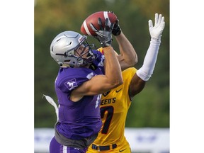 Brett Ellerman of the Western Mustangs hauls in a pass under coverage from Perry Amankwaah of the Queen's Gaels in Ontario university football action Monday night at Western's TD Stadium. Ruttan/The London Free Press)
