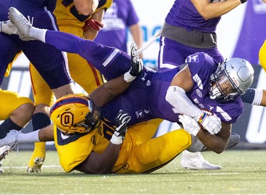 Yann Ky of the Queen's Golden Gaels tackles Western Mustang  ball carrier Trey Humes n the first quarter of the Mustang's home opener at TD Stadium in London, Ont. on Monday September 2, 2019. Derek Ruttan/The London Free Press/Postmedia Network