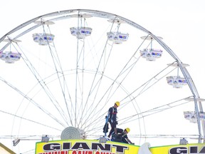 Jaun Jacques Malan of South Africa (left) and Treaque Leader of Calgary work atop the roof of The Polar Express in the shadow of the Ferris wheel during the construction phase of the Western Fair in London, Ont. last week.  Derek Ruttan/The London Free Press/Postmedia Network