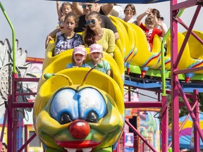 The Berg sisters, nine year old Leigha (left) and six year old Jillian, ride the Wacky Worm Rollercoaster during Western Fair's Day of Dreams in London, Ont. on Wednesday September 11, 2019. The fair opened early on Wednesday exclusively for children with special needs aged 3-12. The free event provided the children with access to rides, entertainers, and animals in an envirionment free of noise and crowds. Derek Ruttan/The London Free Press/Postmedia Network