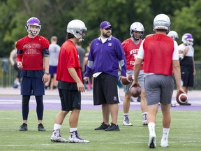 New coach Gaetan Richard works with Western Mustang quarterbacks during team practice at TD Stadium in London. (Derek Ruttan/The London Free Press)