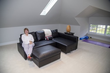 Suzanne Welsh relaxes in the attic of her home at 270 Huron St., finished with skylights and storage as a guest, television or exercise space.  Derek Ruttan/The London Free Press/Postmedia Network
