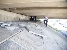 Garda World security guards (L to R) Mitch Cowan, Brian Jordan and Adam George remove needles and other drug paraphernalia from beneath the Adelaide Street bridge that spans York Street in London, Ont. on Wednesday September 18, 2019. The city has hired the firm to keep the area clear of people because of recent vandalism to cement slabs under the bridge. The destruction of the slabs not only threatens the integrity of the structure but when thrown or rolled down the hill is an endangerment to pedestrians and vehicles below. Guards will assigned to the bridge 24 hours a day. Derek Ruttan/The London Free Press/Postmedia Network