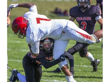 Martin Hunter of the Clarke Road Trojans tackles Keyshaun Cuff of the Saunders Sabres during the United Way game in London on Thursday Sept. 19, 2019. Students were allowed to miss classes and attend the game by purchasing a ticket to the United Way fund raiser. (Derek Ruttan/The London Free Press)