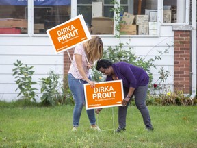 New Democrat candidate Dirka Prout, right, minds the election ground war Tuesday, staking signs for her London-North-Centre campaign on Florence Street with help from volunteer Carla Joubert. Derek Ruttan/The London Free Press/Postmedia Network