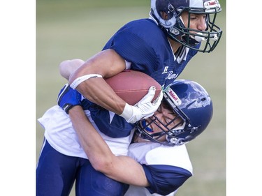 Laurier ball carrier Yaseen Muhammed is brought down by Parkside's Carson Cooper in TVRA action in London on Thursday. (Derek Ruttan, The London Free Press)