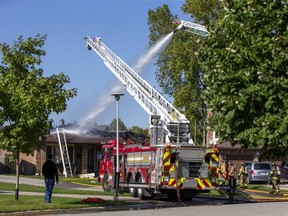 Firefighters work on dowsing a fire at 30 Parkside Cres. in London, Ont. on Monday. A witness said the house was set ablaze by a barbecue. Derek Ruttan/The London Free Press/Postmedia Network