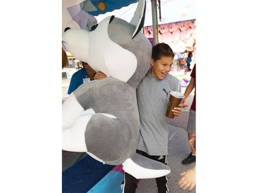 Darcy Corbiere, 14, celebrates his big prize at the age-old ring toss at the Western Fair's opening day on Friday. Corbiere says the large stuffed animal is going to a baby cousin. (Mike Hensen/The London Free Press)