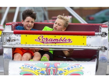 Cooper Hart, 9, should have known better than to sit in the outside seat as he's repeatedly crushed by six-year-old Carson Schmidt during a birthday outing at the Western Fair's opening day on Friday. (Mike Hensen/The London Free Press)