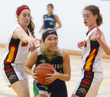 Laurier's Andrea Smith drives between Layall Birani and Bailey Austin of the Saunders Sabres Olivia Hatchett of the Laurier Rams protects the ball as she goes in on Naomi Tufts of the Saunders Sabres during their TVRA Central senior girls basketball game at Saunders on Monday September 30, 2019. 
Laurier dominated throughout with a good press and defence that forced the Sabres to cough up a lot of turnovers.
Mike Hensen/The London Free Press/Postmedia Network