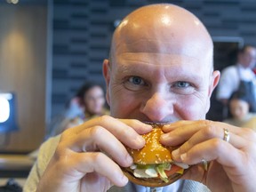 Jason Lessif, franchise owner for the McDonalds on Dundas Street just east of Clarke Road, bites into their brand new PLT, a plant-based burger that;s being tested for 12 weeks at his restaurant and 27 others exclusively in and around London.  Photograph taken on Monday September 30, 2019.  Mike Hensen/The London Free Press/Postmedia Network