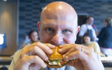 Jason Lessif, franchise owner for the McDonalds on Dundas Street just east of Clarke Road, bites into their brand new PLT, a plant-based burger that;s being tested for 12 weeks at his restaurant and 27 others exclusively in and around London.  Photograph taken on Monday September 30, 2019.  Mike Hensen/The London Free Press/Postmedia Network