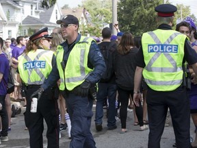 A police constable disposes of a confiscated can of beer during a student party in September 2014. Police have relaunched their student education program called Project LEARN, to teach students about legal, respectful behaviour.