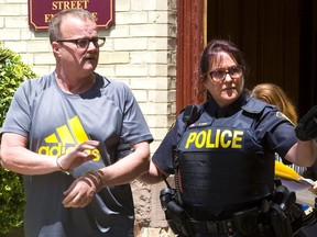 Ex-OPP officer John Paul Stone is led out of court in Stratford after being sentenced to 18 months on two charges of child pornography. (Mike Hensen/Postmedia Network)